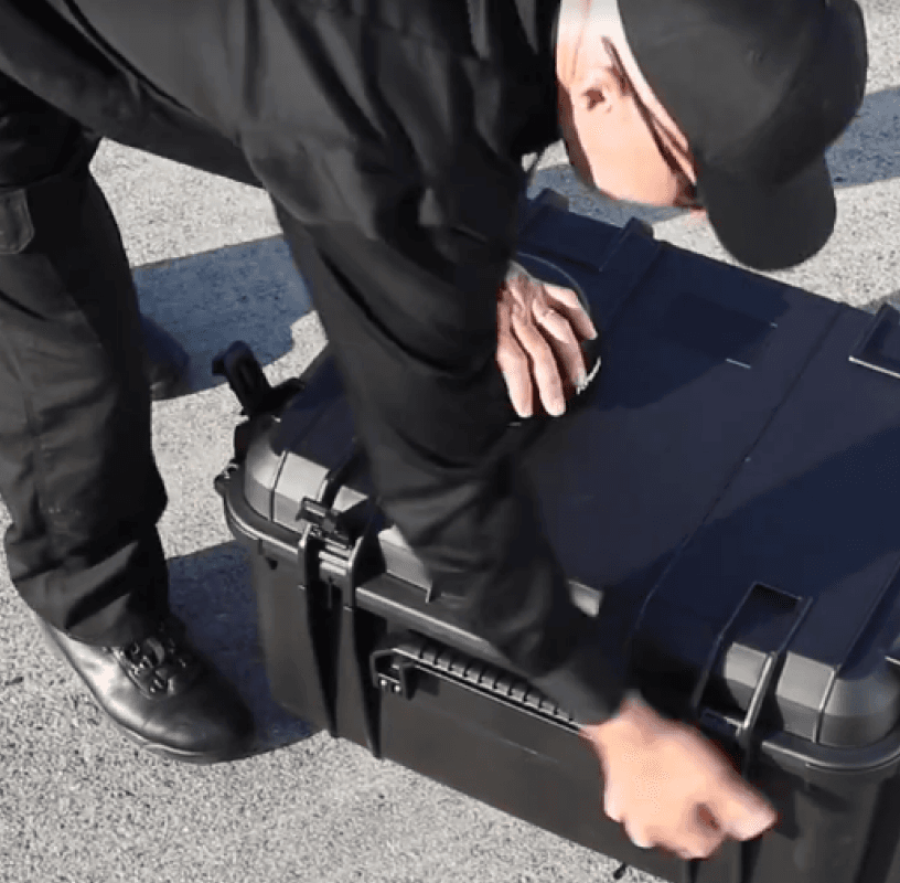 Law enforcement officer deploying a Rapid Deploy Kit on a vehicle rooftop at night